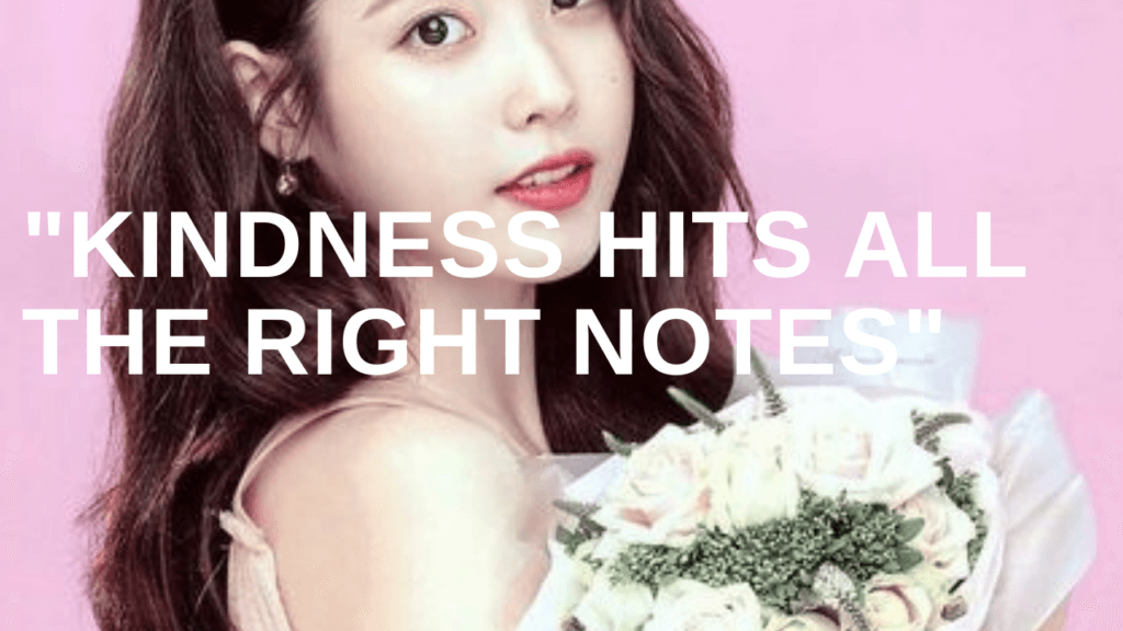 IU is putting on a baby pink gown, with a bouquet on her hand.