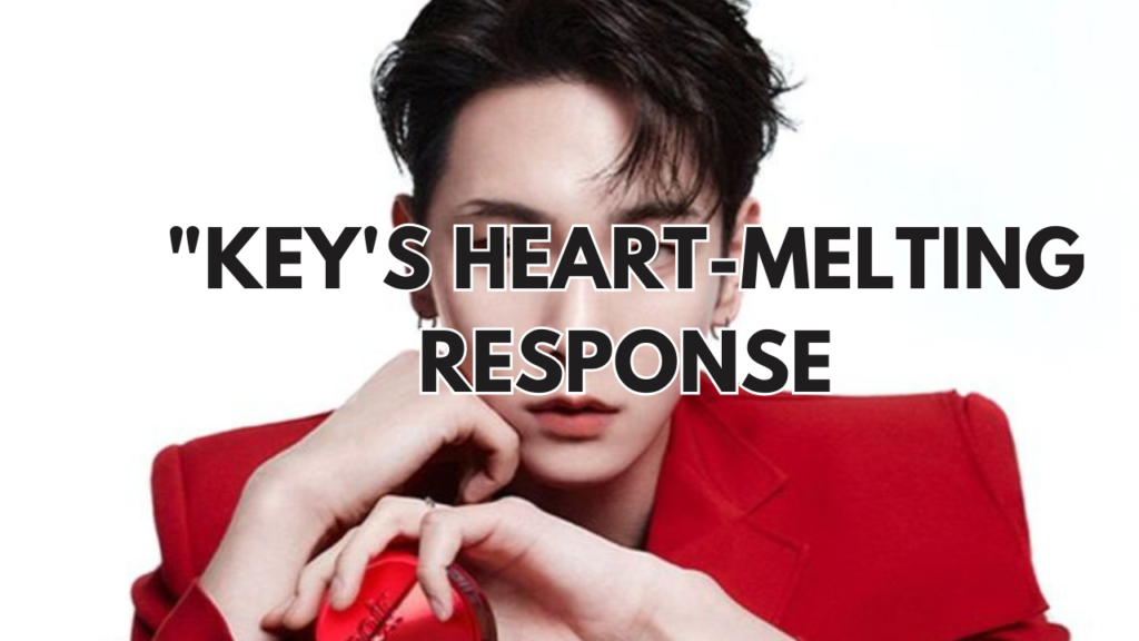 shinee's key on a red suit with his hand on his chin